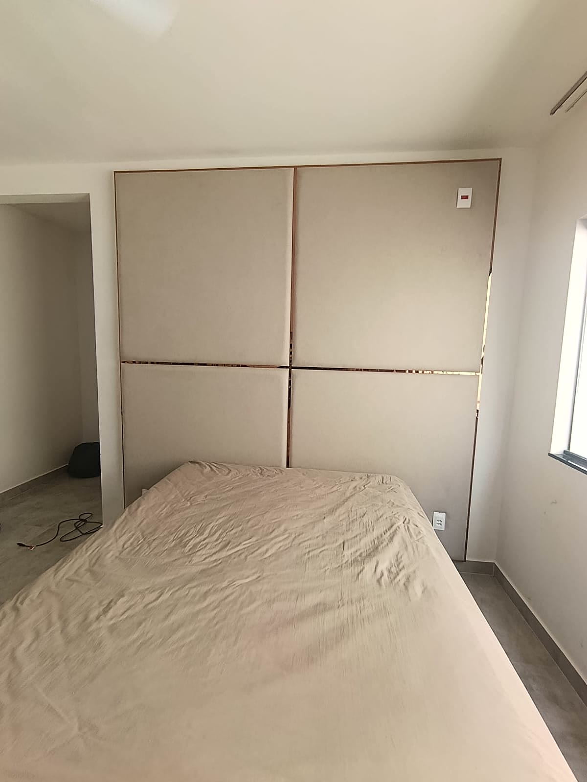 Painel estofado de parede com filetes metálicos